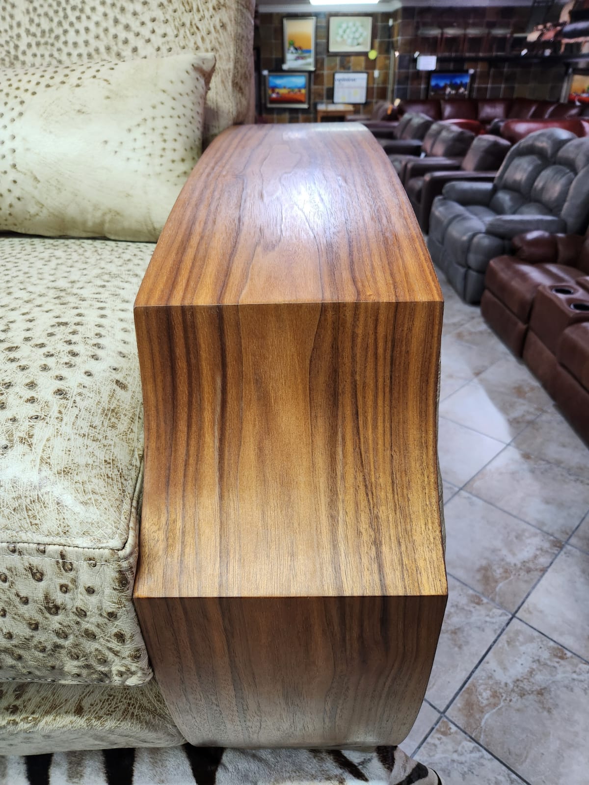 Front and walnut arm detail of genuine ostrich leather sofa